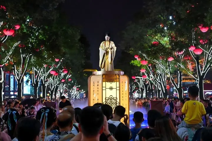 西安大唐不夜城的演员“李白”与游客对诗互动（2024年7月9日摄）。新华社记者邹竞一摄